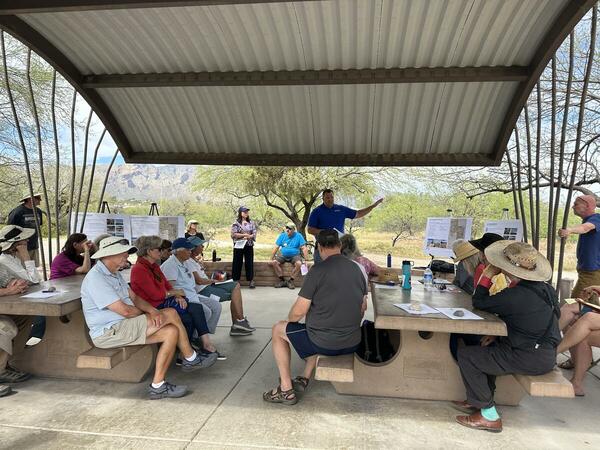 A group of people meet under a ramada