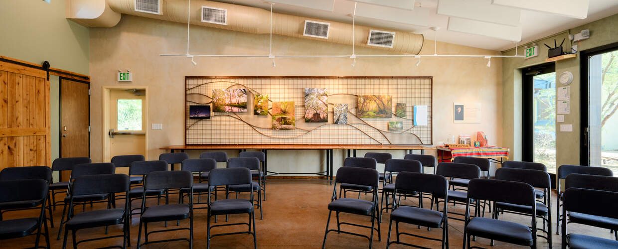 Chairs in classroom style setup with wall of river photos behind them