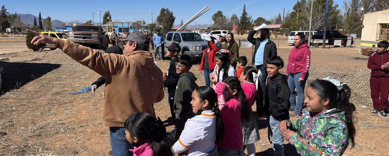Group of elementary school children and adults getting ready to work on a project