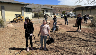 Children moving plants and irrigation line in a basin