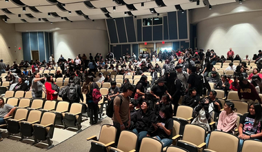 A group of high school students in an auditorium